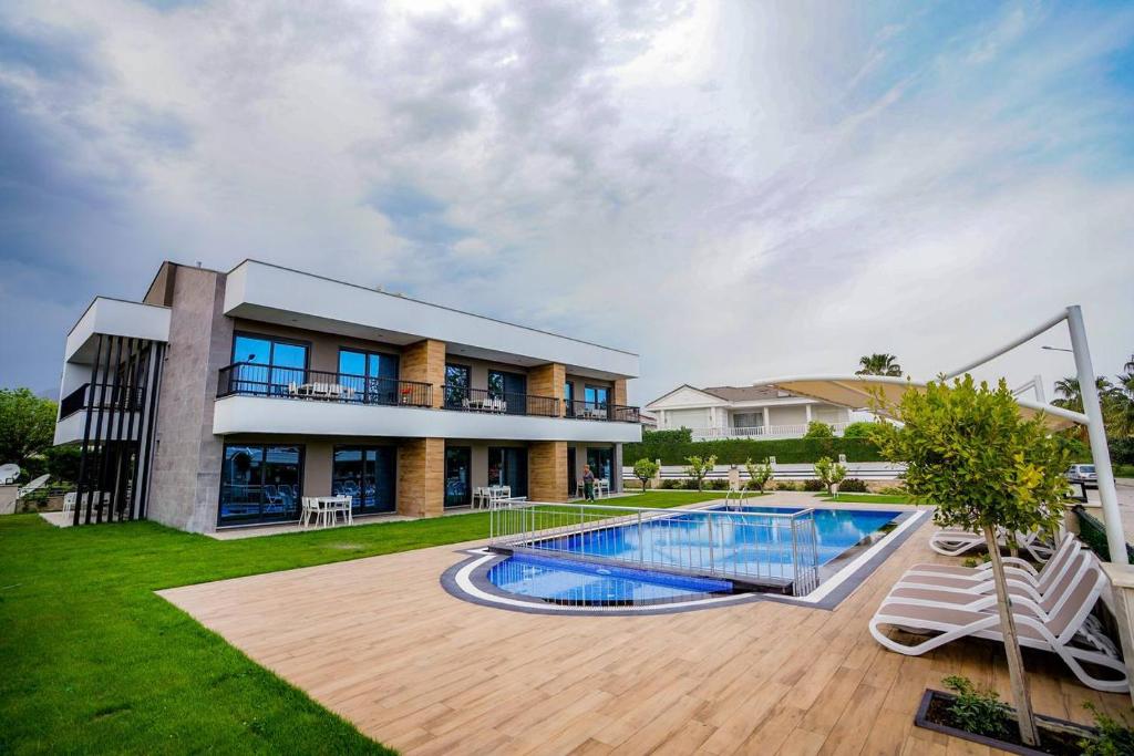 a house with a swimming pool in the yard at Sweet Home Kemer Apartments in Kemer