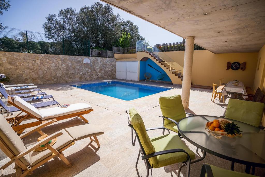 a patio with a table and chairs and a swimming pool at Can Salgas in Montrás