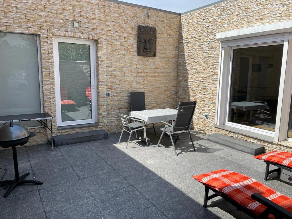 d'une terrasse avec une table et des chaises à côté d'un mur en briques. dans l'établissement Bungalow mit Terrasse, à Ratisbonne