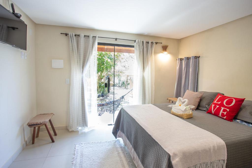 een slaapkamer met een bed en een groot raam bij Pousada Beija-Flor in Alto Paraíso de Goiás