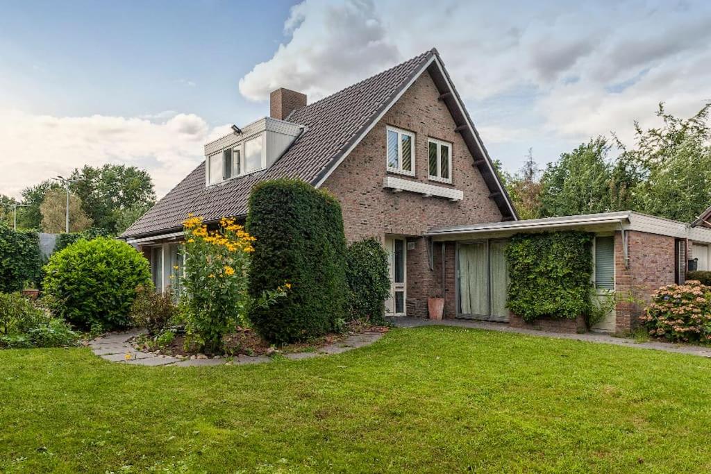 uma casa de tijolos com arbustos e um quintal em Front room in Villa near Centre and TUe em Eindhoven