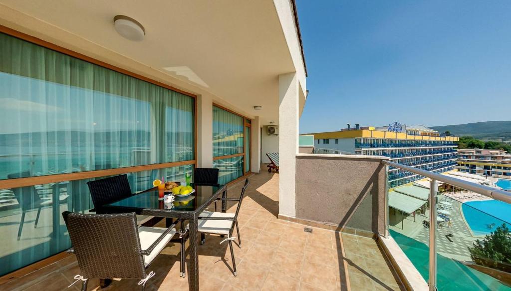 a balcony with a table and chairs on a building at Briz Beach Apartments in Sunny Beach