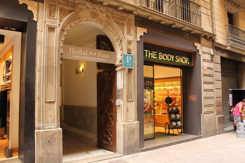 an entrance to a shop with a sign for the body shop at Hostal Fina in Barcelona