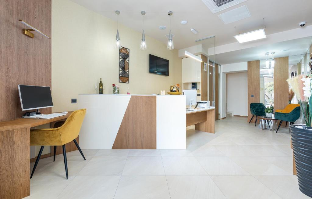 an office with a reception counter and desks and chairs at Hotel Dua Residence in Poreč