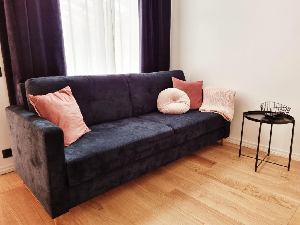 a blue couch with pillows on it in a living room at Supeluse 7-1 Guest Apartment by Annalie Apartments in Pärnu
