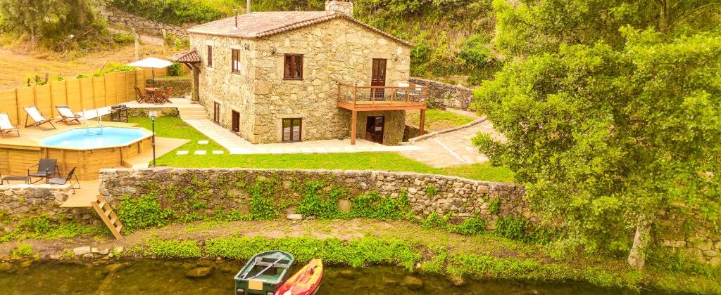 an aerial view of a stone house with a swimming pool at River House - Casas do Rio Tora in Arcos de Valdevez