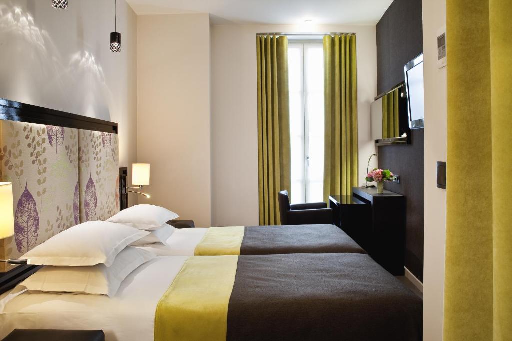 a hotel room with a bed and a window at Hôtel Caron le Marais in Paris