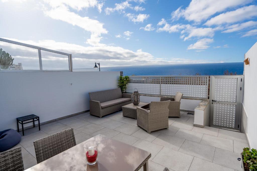 a rooftop patio with a view of the ocean at Luxurious apartment with large terrace and sea views in Tabaiba