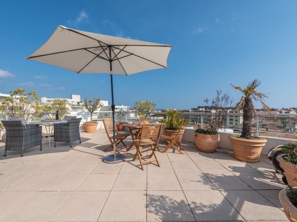 a patio with a table and chairs and an umbrella at Apartment Turquoise-8 by Interhome in Cavalaire-sur-Mer