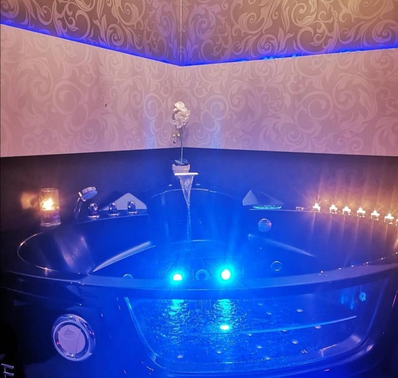 y baño con bañera con luces azules. en Le Loveappart en Pézenas