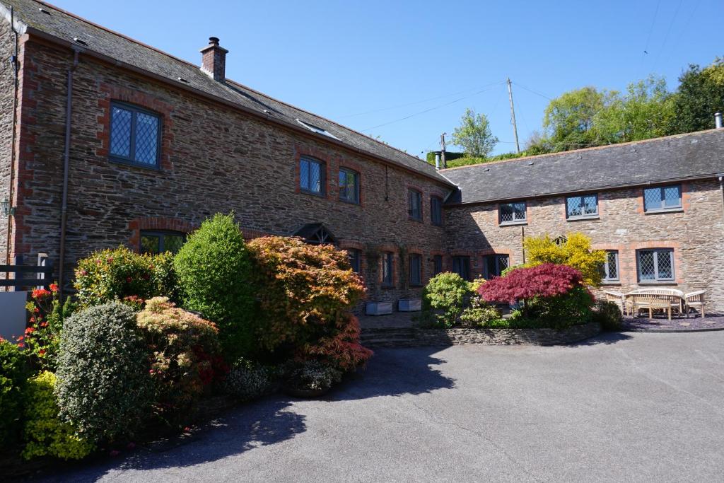 a brick building with flowering plants in front of it at Carlane Court, Slapton, South Devon in Slapton