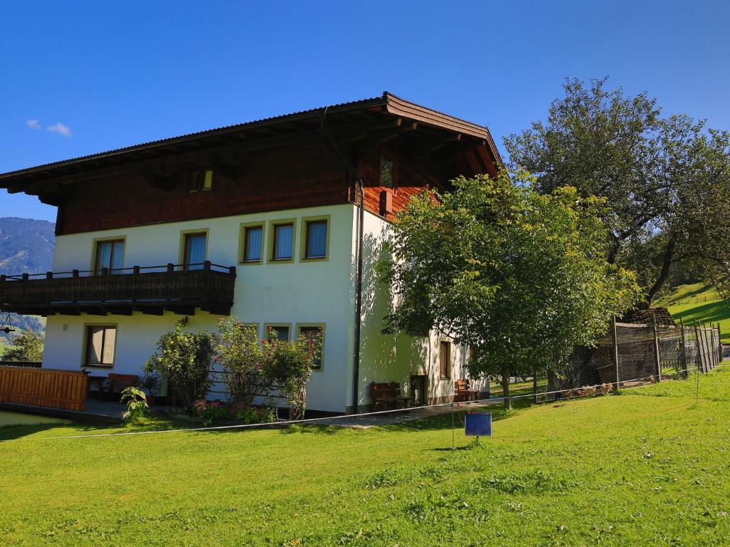 una gran casa blanca con un árbol en el patio en Apartment Oberberghof by Interhome en Uttendorf