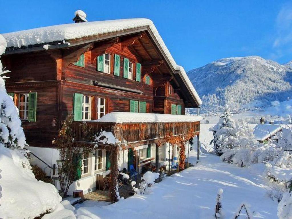 a large wooden house with snow on it at Apartment Hübeli - Kopp by Interhome in Zweisimmen