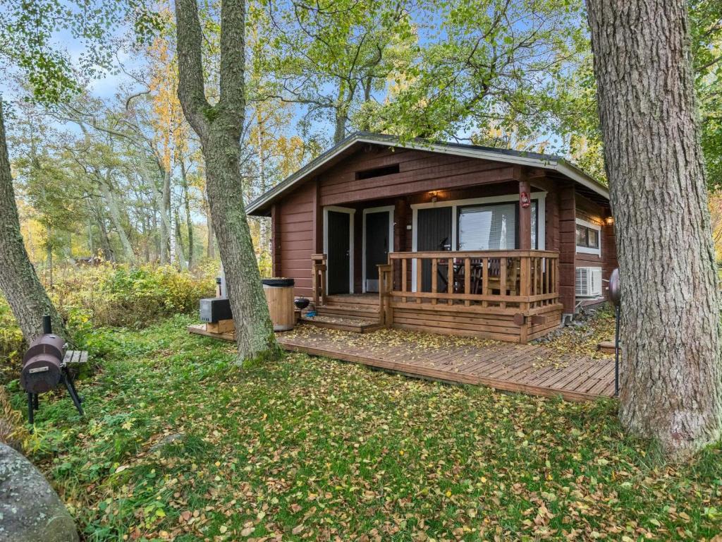 una cabaña en el bosque con terraza y árboles en Holiday Home Anttoora a-sauna by Interhome en Pori