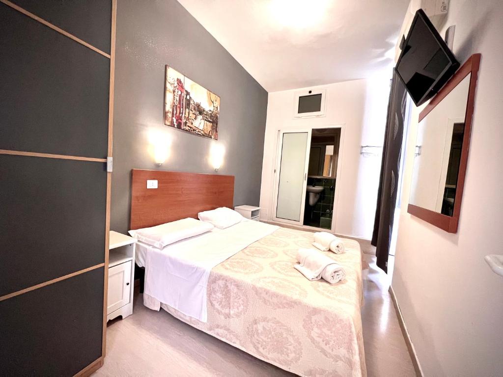 Dormitorio pequeño con cama y TV en Alius and Freerome Hotel en Roma