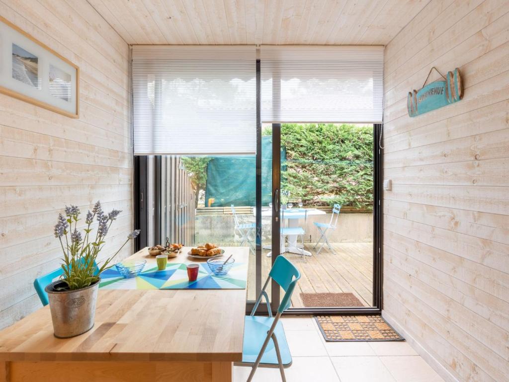 - un salon avec une table et une porte en verre dans l'établissement Holiday Home Les Pins-12 by Interhome, à Lacanau-Océan