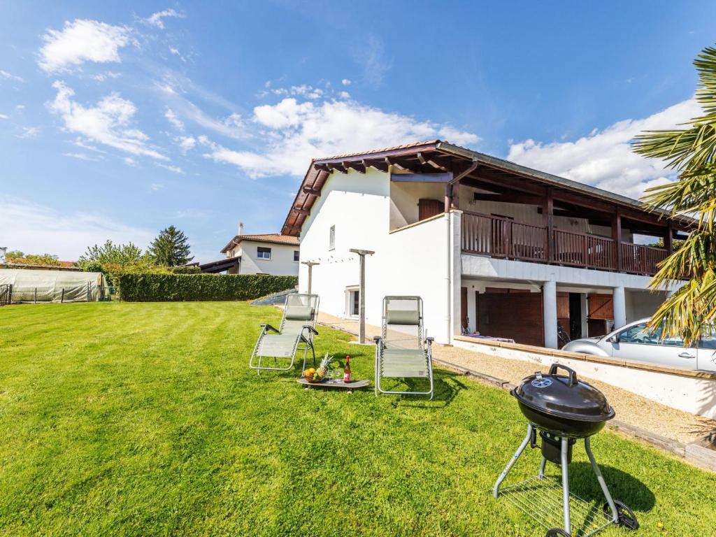 une cour avec des chaises et un barbecue en face d'une maison dans l'établissement Apartment Jardins de Maignon by Interhome, à Anglet