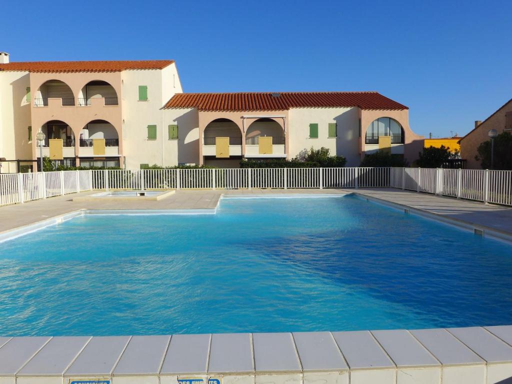 une piscine devant une villa dans l'établissement Apartment Les Patios du Barcarès-3 by Interhome, au Barcarès