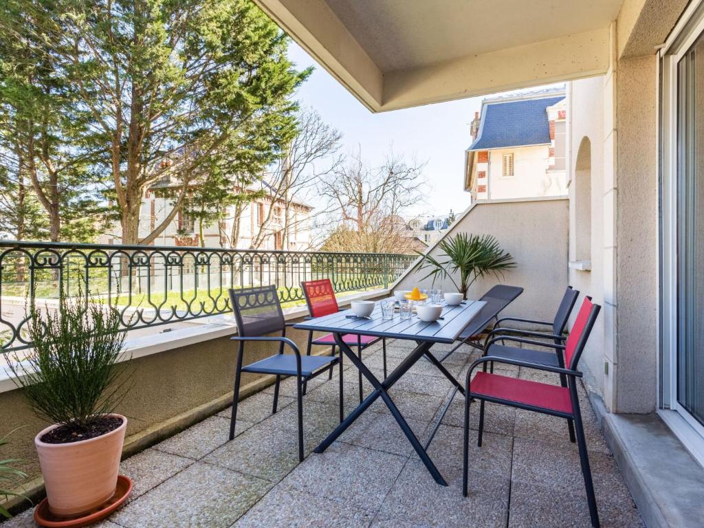 un patio avec une table et des chaises sur un balcon dans l'établissement Apartment Montaigu by Interhome, à Cabourg