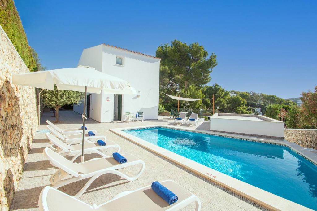 a villa with a swimming pool and lounge chairs at Villa Violeta by Sonne Villas in Cala Galdana