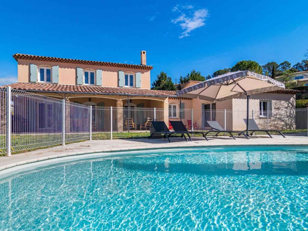une piscine avec deux chaises et une maison dans l'établissement Holiday Home Villa Liliarty by Interhome, à Carcès
