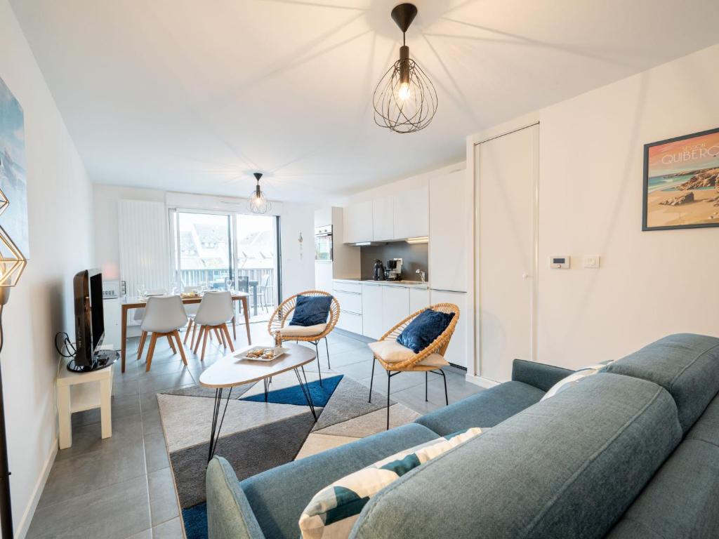a living room with a blue couch and a table at Apartment Résidence Coté Baie by Interhome in Saint-Pierre-Quiberon