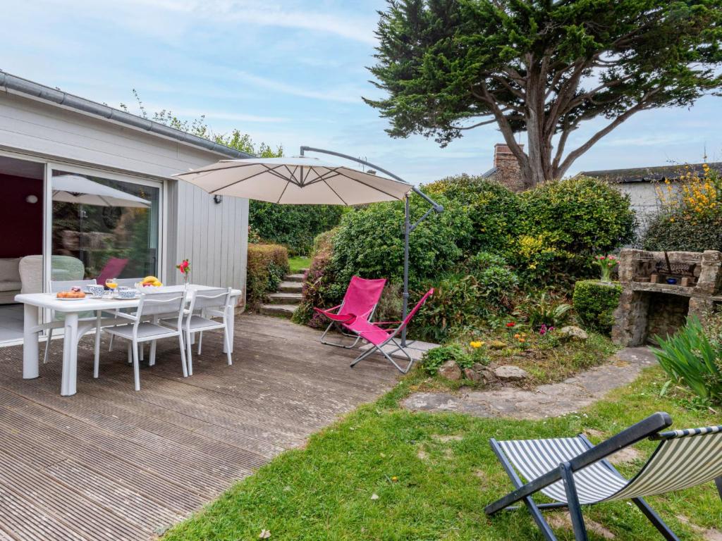 a patio with a table and chairs and an umbrella at Holiday Home Le havre de paix by Interhome in Créances