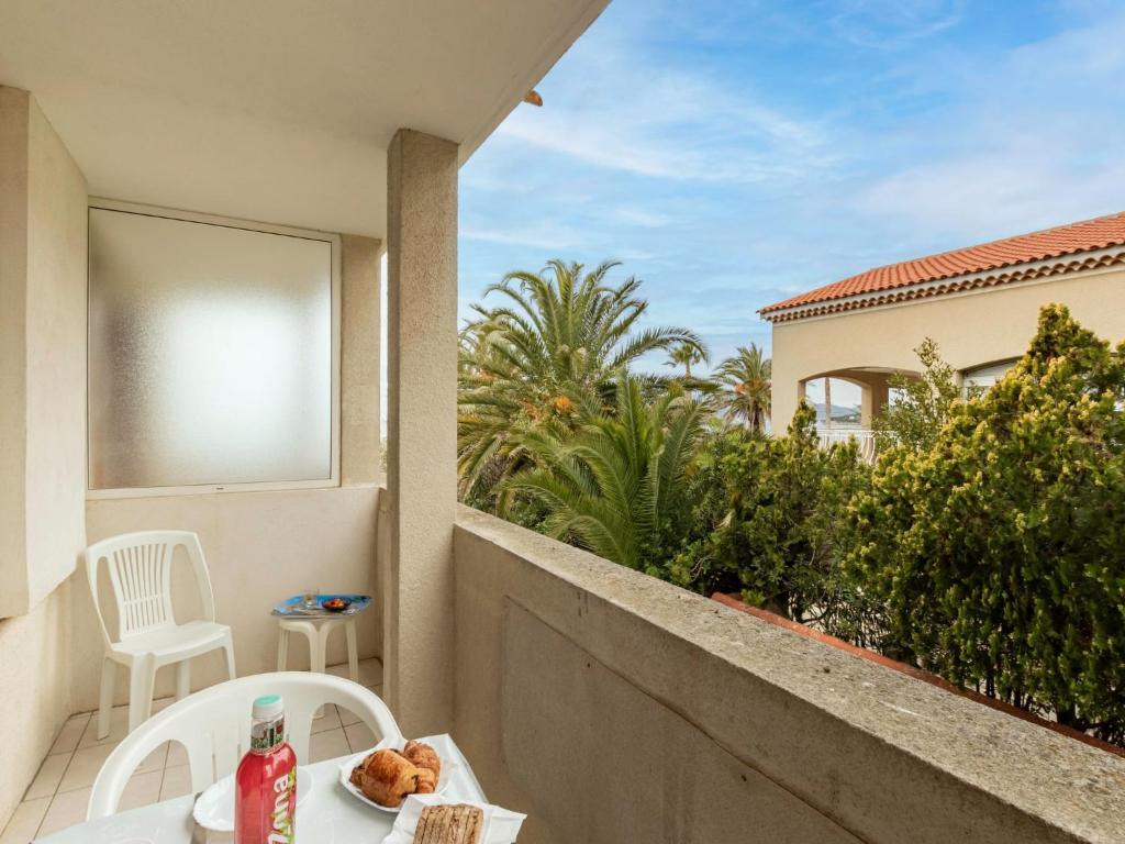 une table avec une assiette de nourriture sur un balcon dans l'établissement Apartment Super Plage-8 by Interhome, à Saint-Cyr-sur-Mer