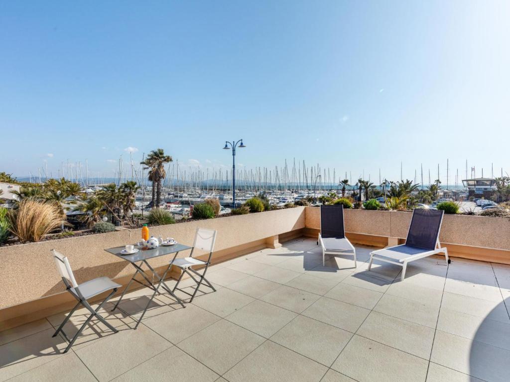 un patio avec des chaises et une table sur un balcon dans l'établissement Studio Port de La Gavine-25 by Interhome, à Hyères