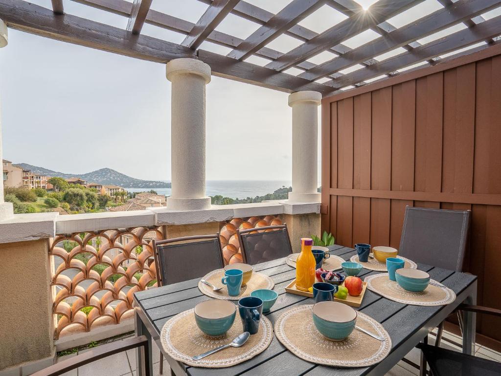 une table avec des assiettes de nourriture sur un balcon dans l'établissement Apartment L'Esquinade J5 226 by Interhome, à Agay