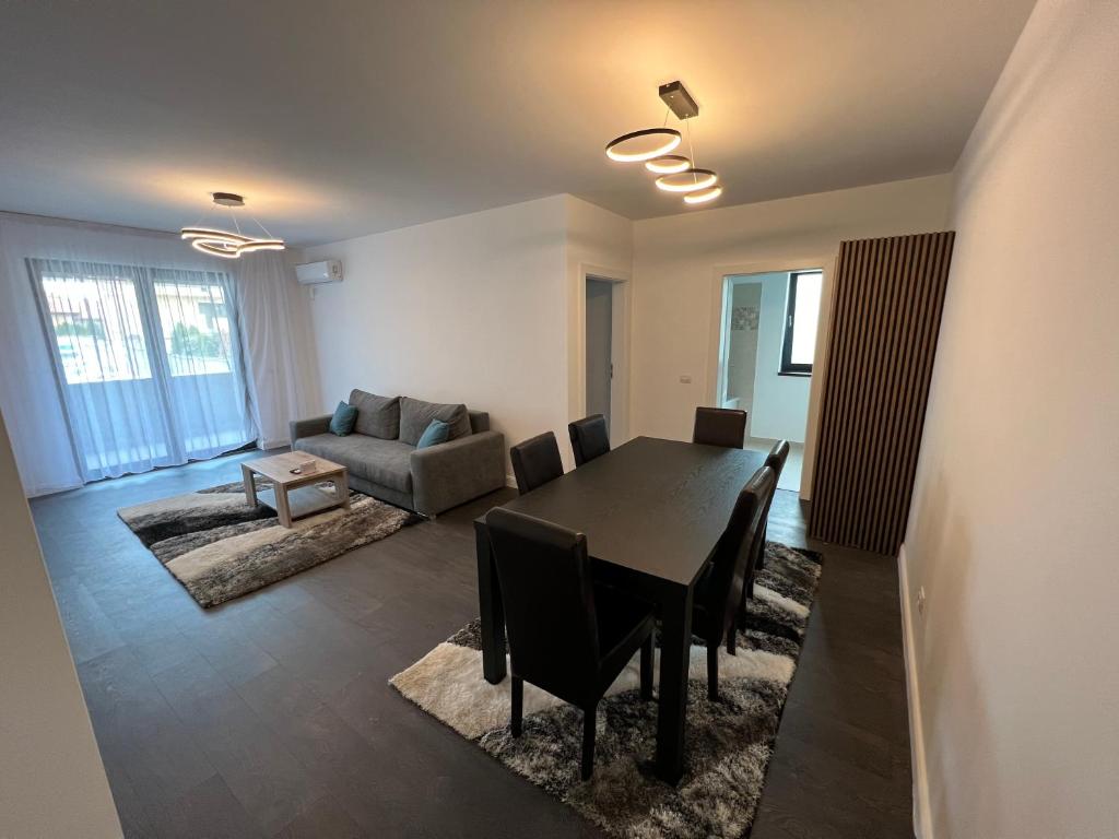 een woonkamer met een tafel en een bank bij Apartament lux zona stadion ion oblemenco in Craiova