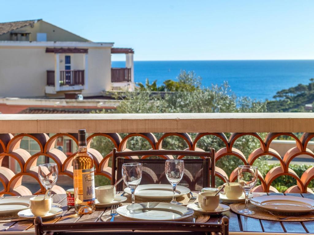 - une table avec des verres et une bouteille de vin sur le balcon dans l'établissement Apartment L'Esquinade - P5 317 by Interhome, à Agay