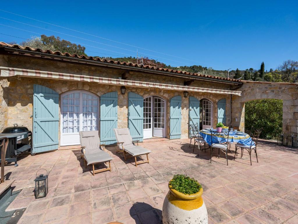 eine Terrasse mit einem Tisch und Stühlen sowie ein Gebäude in der Unterkunft Holiday Home Villa Chaumado by Interhome in Spéracèdes