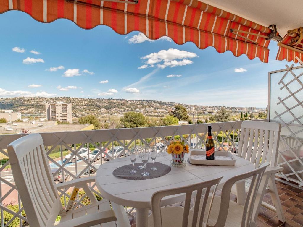 d'une table et de chaises sur un balcon avec vue. dans l'établissement Apartment Le Giono by Interhome, à Saint-Laurent-du-Var