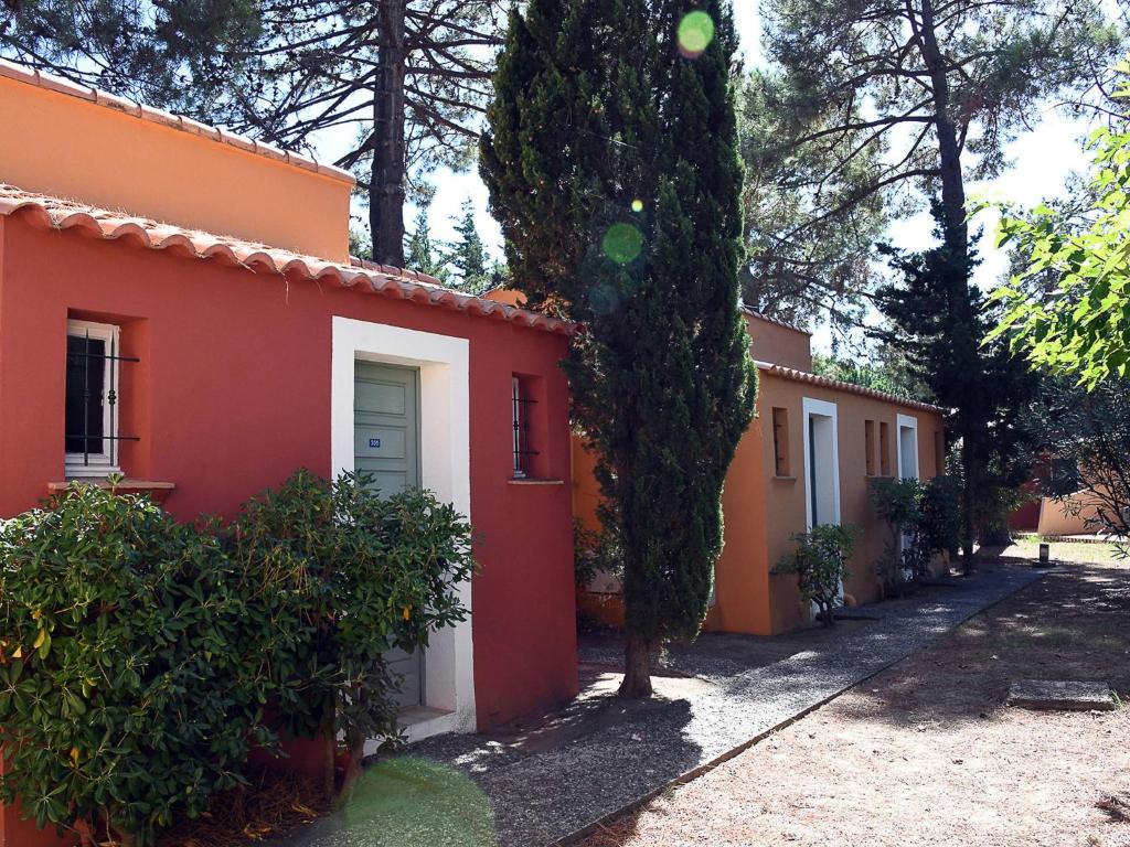 une maison orange et blanche avec un arbre à côté dans l'établissement Holiday Home Cala Bianca-1 by Interhome, à Borgo