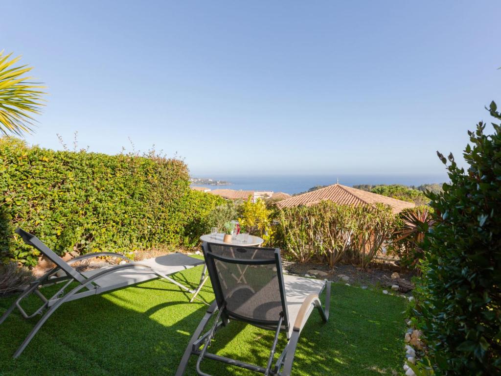 une table et une chaise assises sur une pelouse dans l'établissement Apartment Les Bastides - O4 023 by Interhome, à Agay