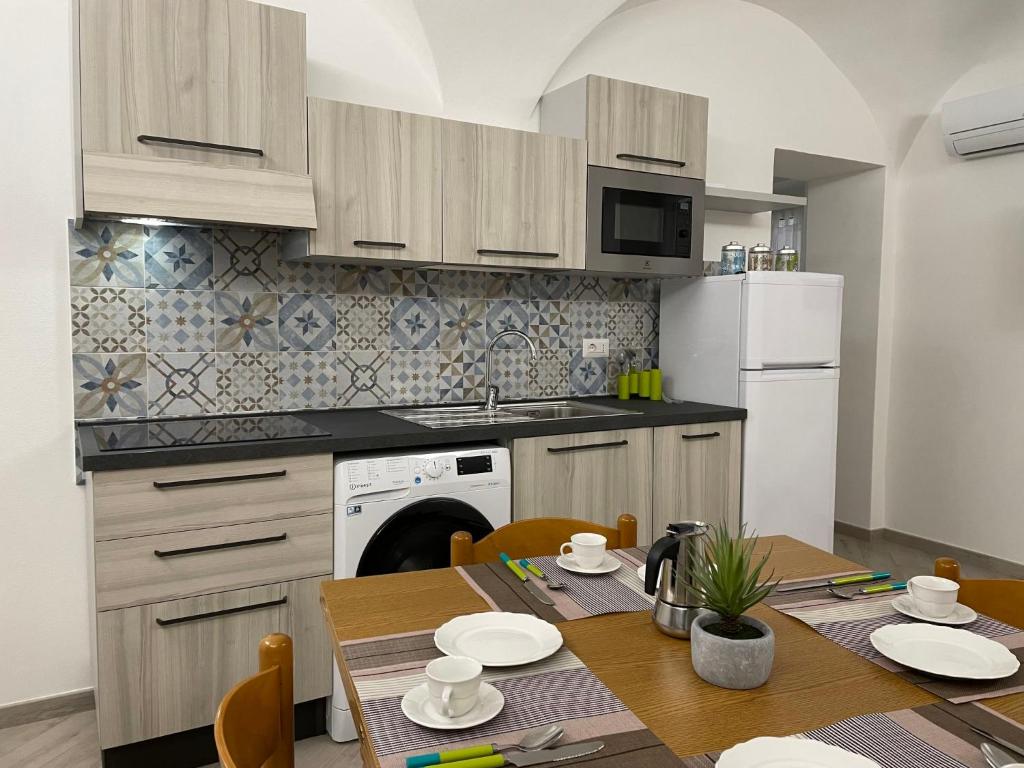 eine Küche mit einem Tisch und einem weißen Kühlschrank in der Unterkunft Apartment Tra Sole e Mare by Interhome in Spotorno