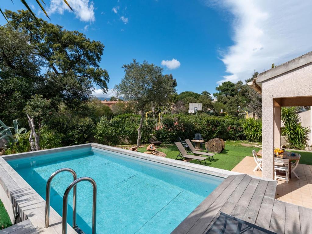 a swimming pool with a patio and a yard at Holiday Home Villa Vaccaja by Interhome in Porto-Vecchio