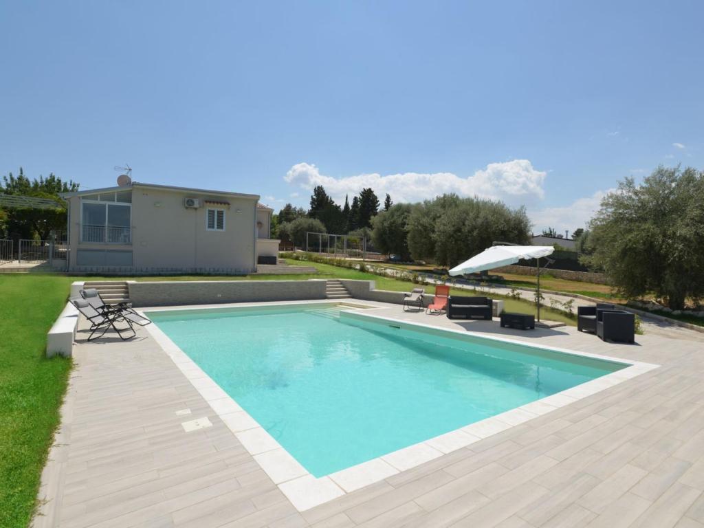een zwembad in een tuin met een huis bij Villa Paolina by Interhome in Solarino