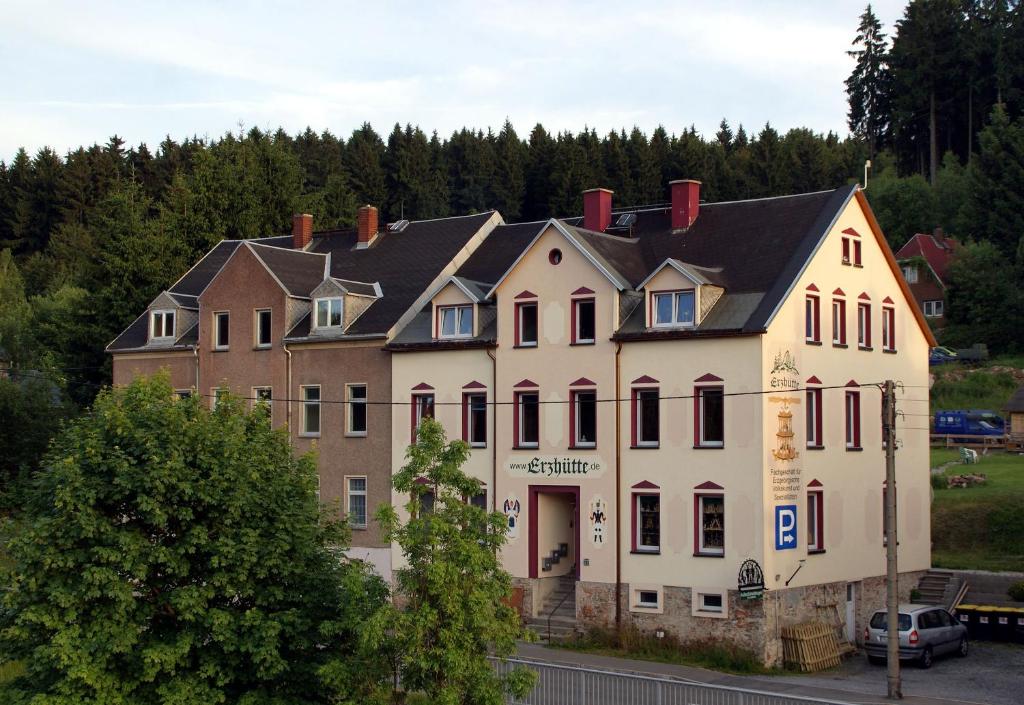 a large white building with a black roof at Ferienwohnung Erzhütte in Rechenberg-Bienenmühle