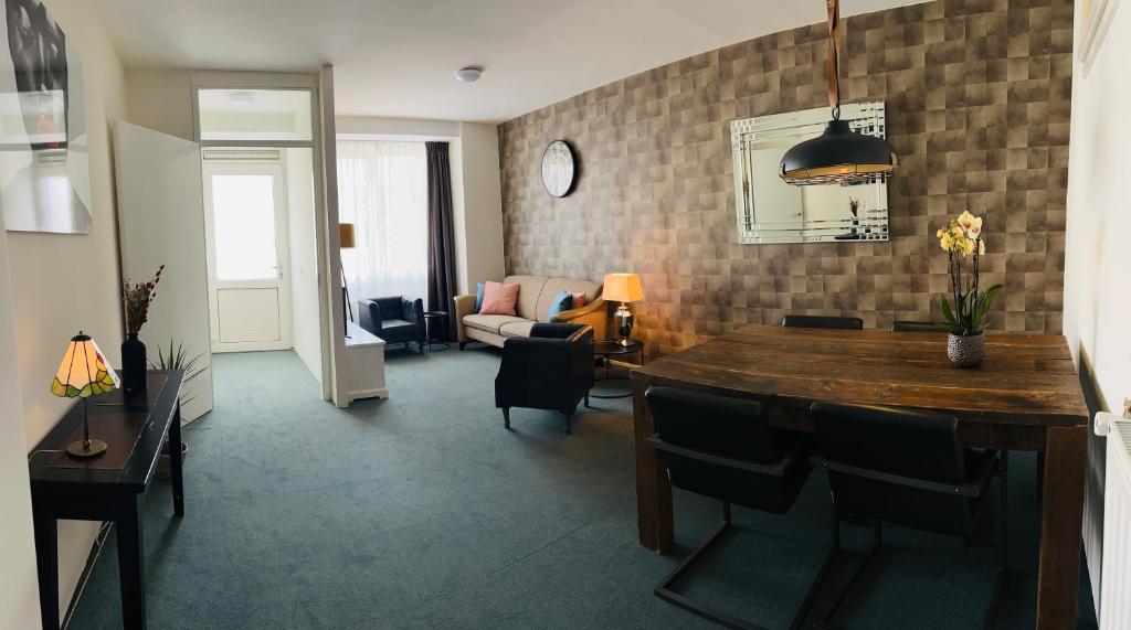 een woonkamer met een tafel en stoelen en een woonkamer bij Shoreline Apartment Katwijk in Katwijk aan Zee
