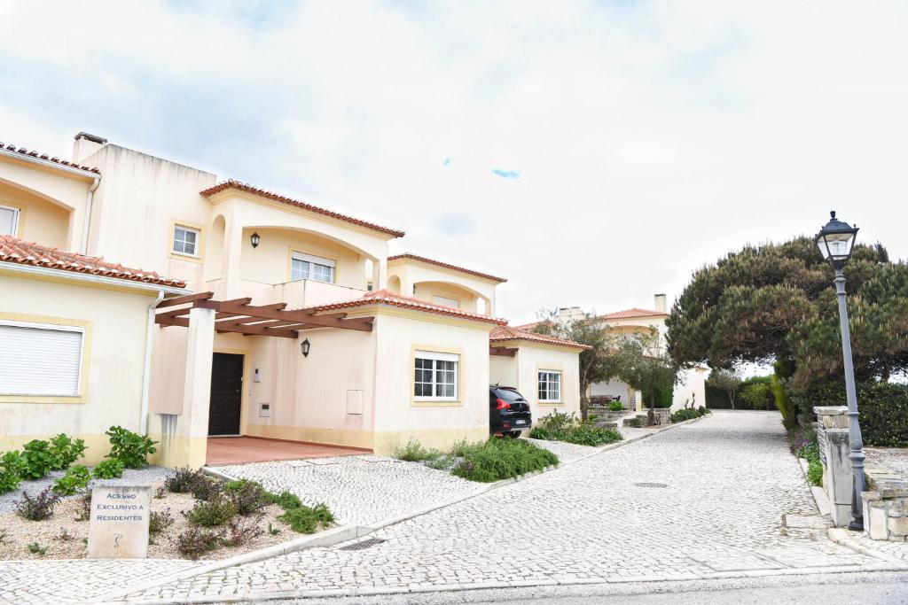 uma casa com uma luz de rua ao lado de uma entrada em Casa Louisa em Praia del Rei