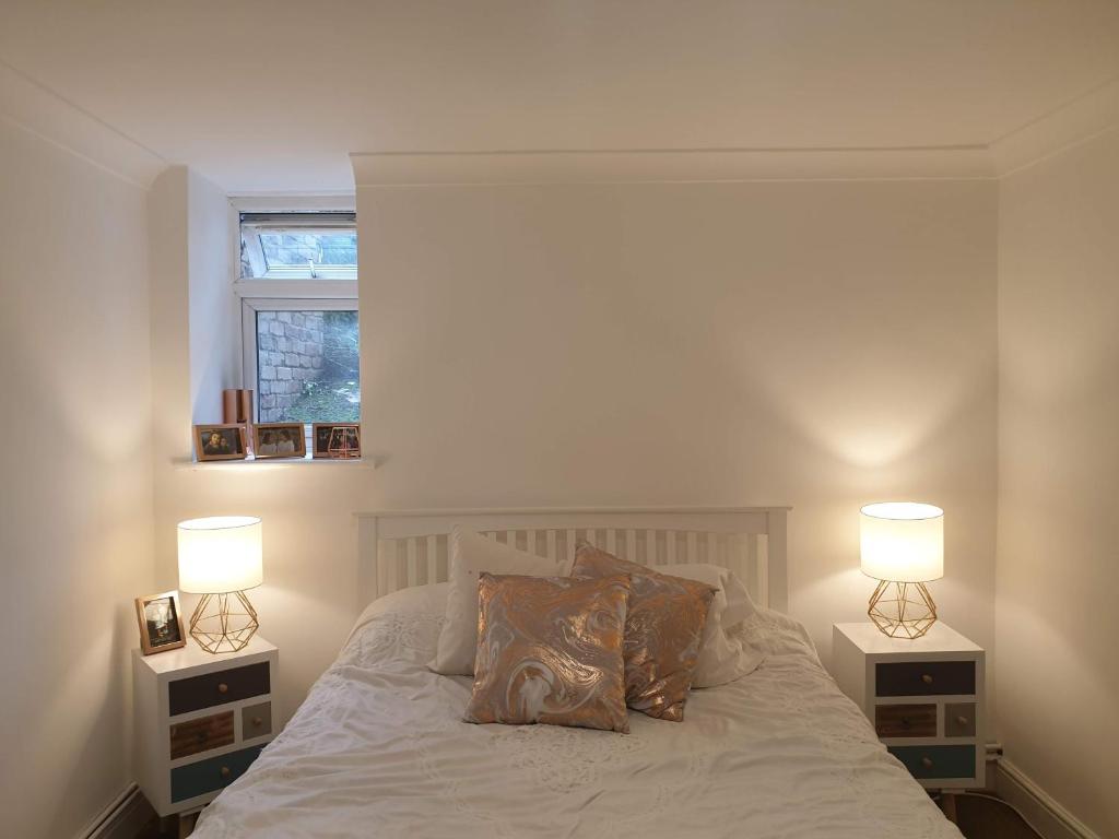 a bedroom with two lamps on the sides of a bed at Cozy Muswell Hill 1-Bedroom Flat in London