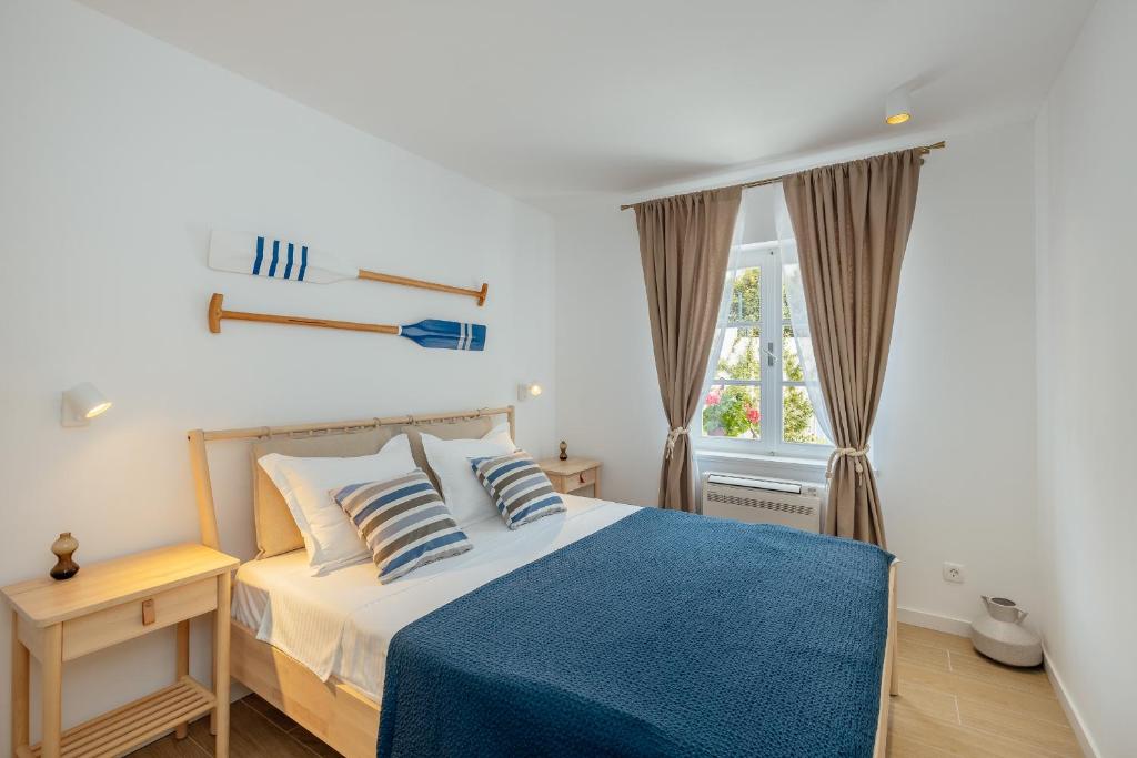 a bedroom with a bed with a blue blanket and a window at Magnolia Apartments 1 Herceg Novi in Herceg-Novi