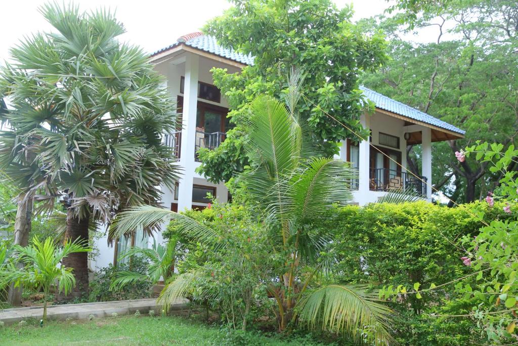 a white house with trees in front of it at Gatetrees resort in Jaffna