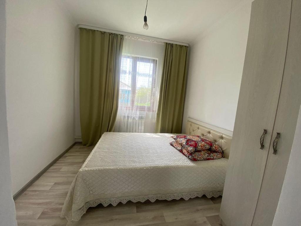 a small bedroom with a bed and a window at Guest House Arcabay-Karligash in Saty