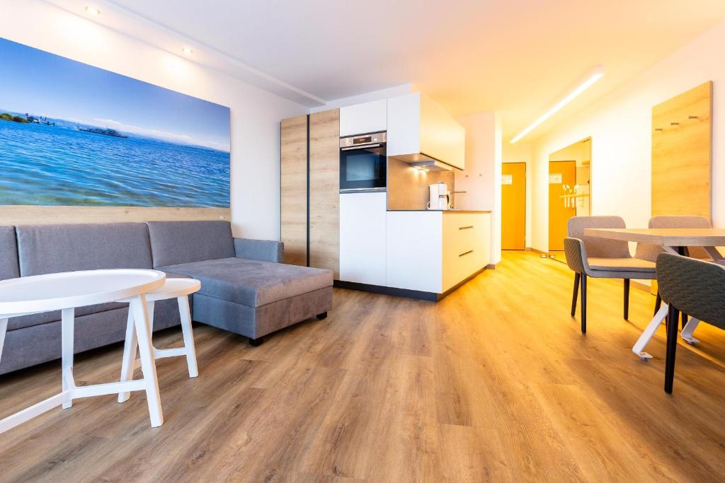 博登斯边的伊门施塔特Ferienwohnpark Immenstaad am Bodensee Ein-Zimmer-Apartment 53 20的客厅里有一张沙发和一张桌子。