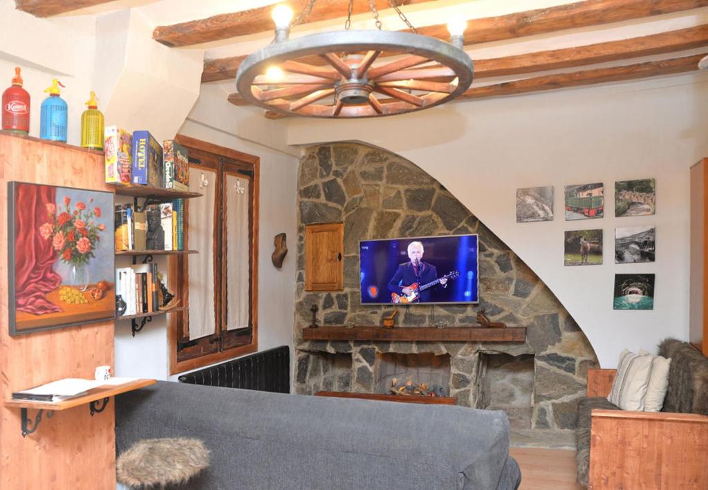 uma sala de estar com uma lareira de pedra e uma televisão em Piso rústico-moderno 6 plazas - Pobla de Lillet em La Pobla de Lillet