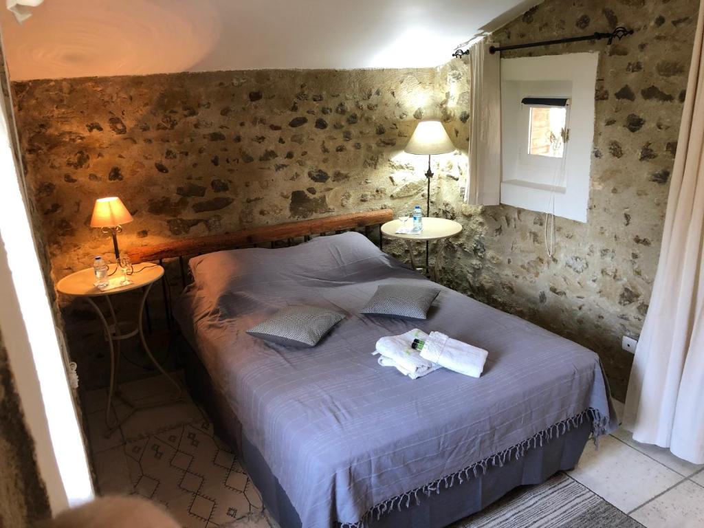CharolsにあるGîtes Lou Patacletのベッドルーム1室(ベッド1台、ランプ2つ、テーブル2台付)