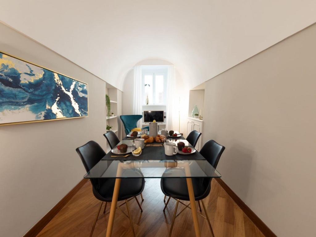 une salle à manger avec une table et des chaises en verre dans l'établissement The Best Rent - Apartment near Piazza di Spagna, à Rome